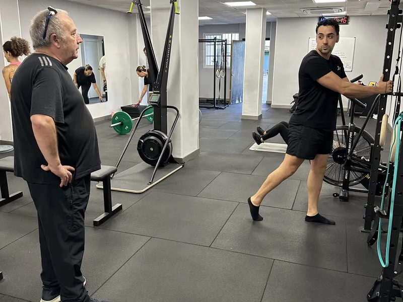 Entrenador enseñando un ejercicio de readaptación a un cliente
